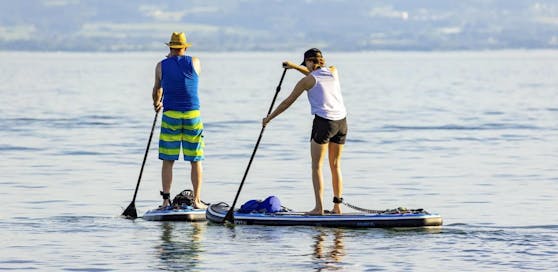 (Symbolbild) Zwei Stand-Up-Paddler an einem See in Deutschland