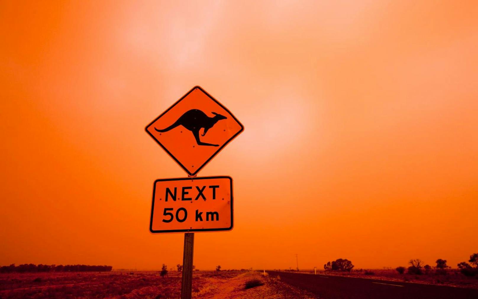 Ein Warnschild im australischen Outback während eines Sandsturms. Symbolfoto