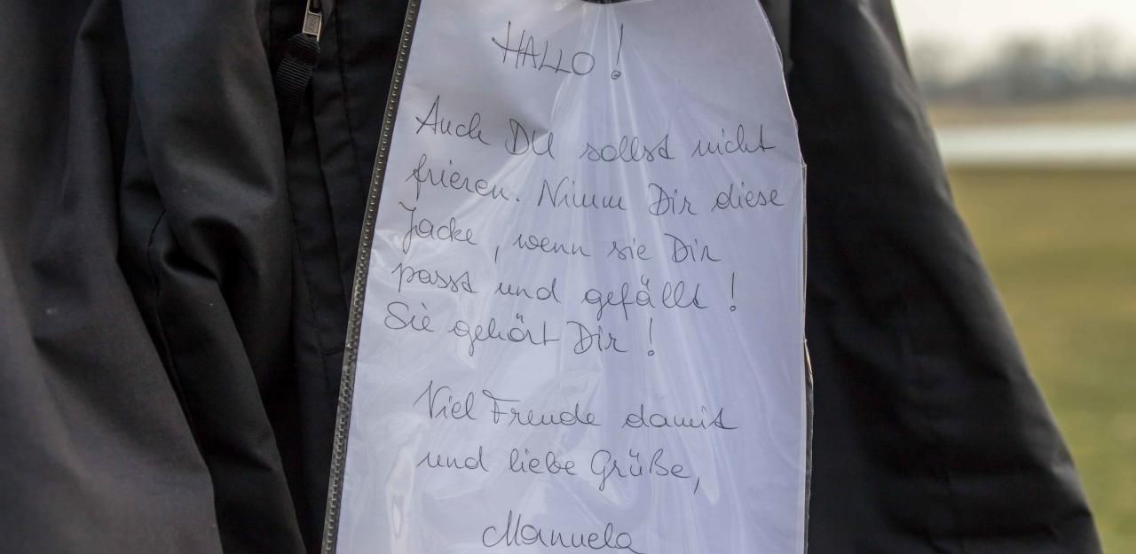 Heute.at - Manuela hängt in Linz Gratis-Jacken an Bäume