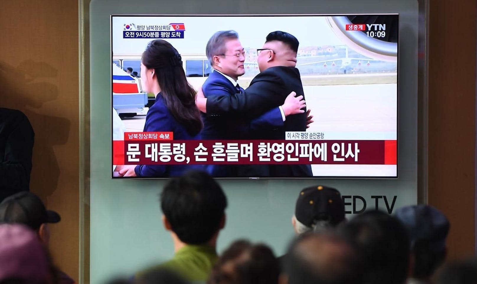 Südkoreas Präsident Moon Jae-in wird von Nordkoreas Staatschef Kim Jong-Un mit einer Umarmung herzlich begrüßt.