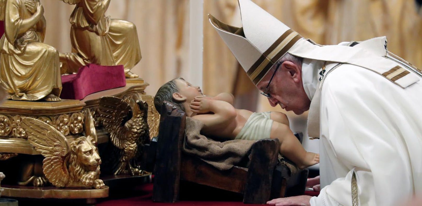 Papst Franziskus küsst eine Statue des Jesuskindes am Heiligen Abend im Vatikan.