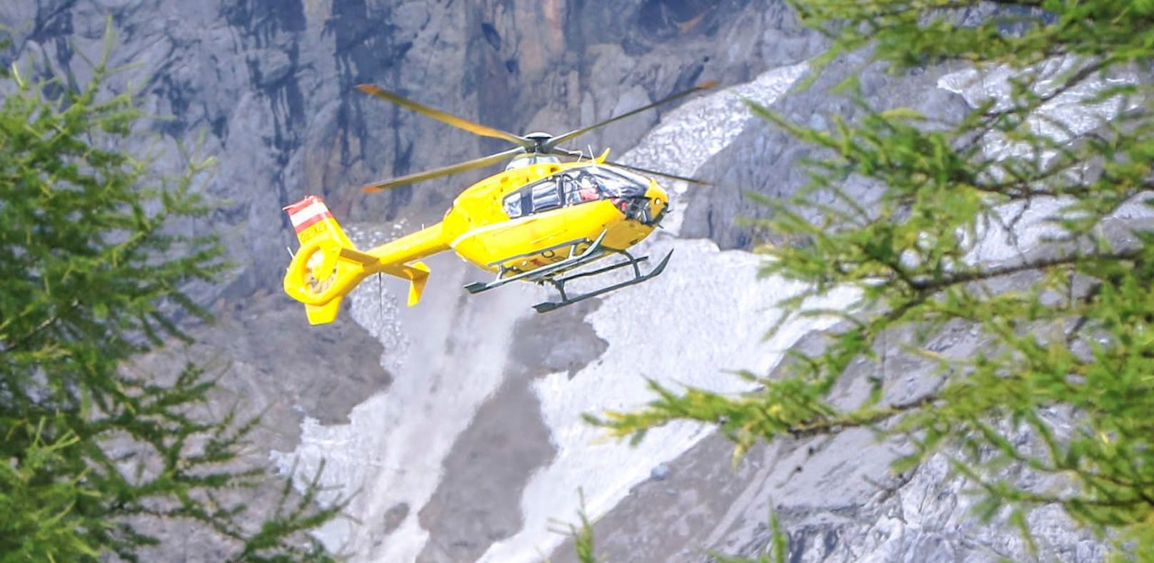 Ein Notarzt-Hubschrauber vom Stützpunkt Christophorus 14 in Niederöblarn vor Felsen und Schneefeldern des Dachstein-Gebirge. Symbolfoto
