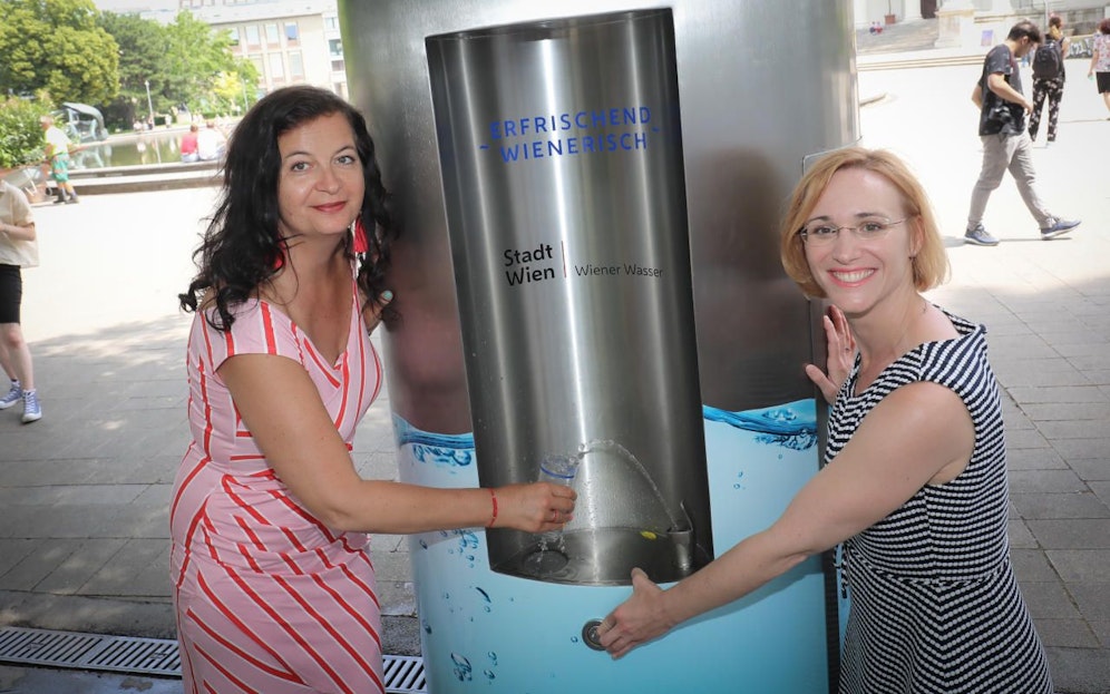 Stadträtin Ulli Sima und Wiedens Bezirksvorsteherin Lea Halbwidl (v.li, beide SPÖ) probierten den tausendsten Trinkbrunnen im Resselpark bei der Karlskirche gleich selbst aus.