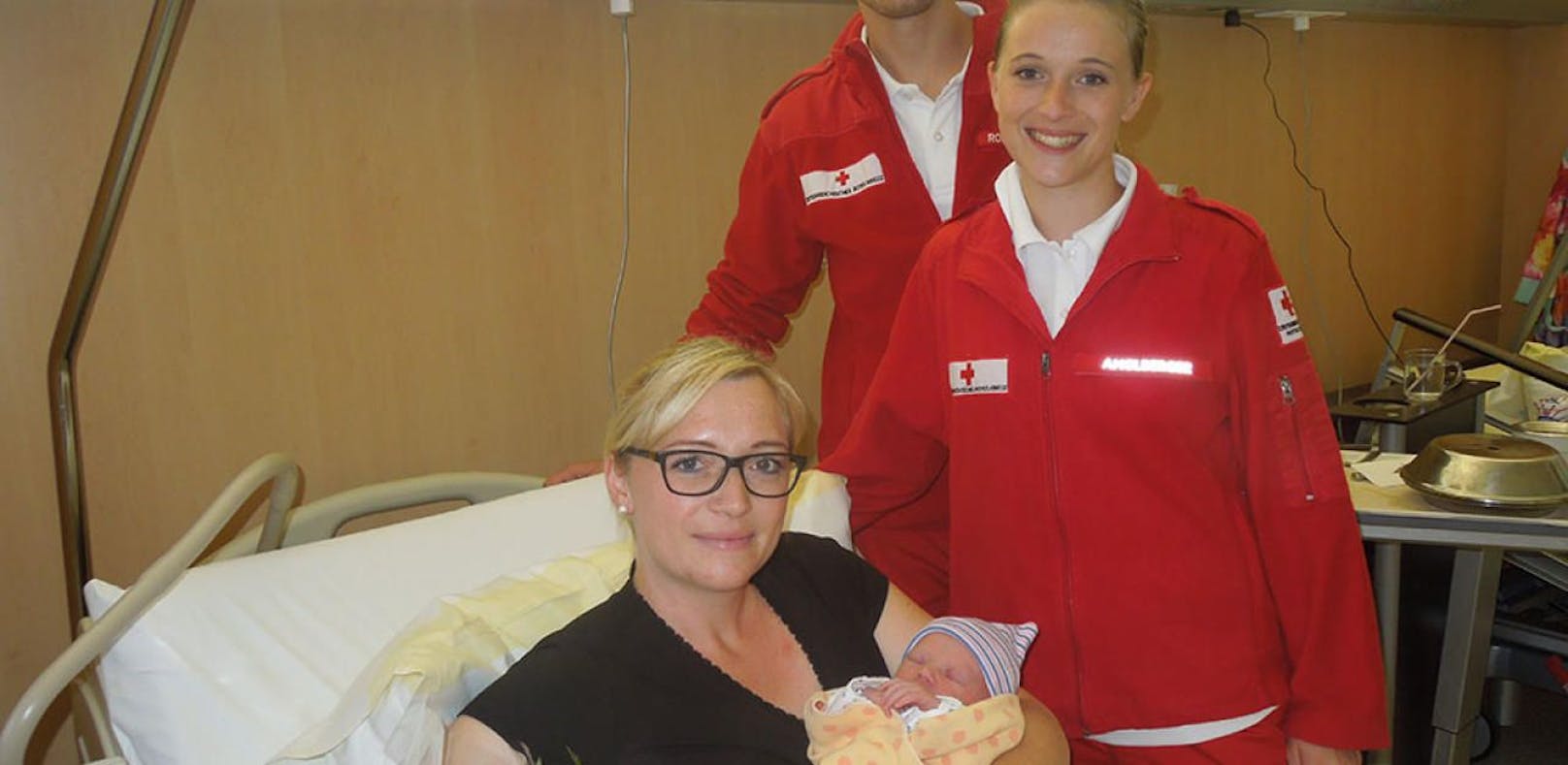 Mama Eva Schmiedinger mit ihrer kleinen Lisa und den beiden Rettungssanitätern vom Roten Kreuz Mattighofen. 