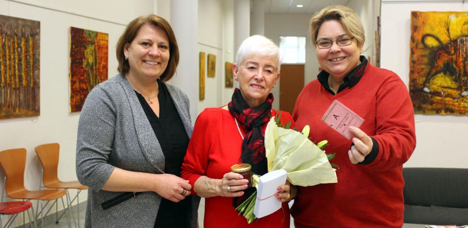 Ernestine Kral freut sich über die Blumen und das Ehrengeschenk von Stadträtin Vera Edelmayr (l.) und Bürgermeisterin Karin Baier (r.).