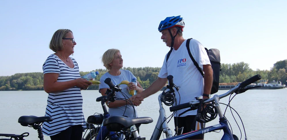 E. Königsberger (mit Radhelm) verteilte Lebensmittel und sicherte Radweg.