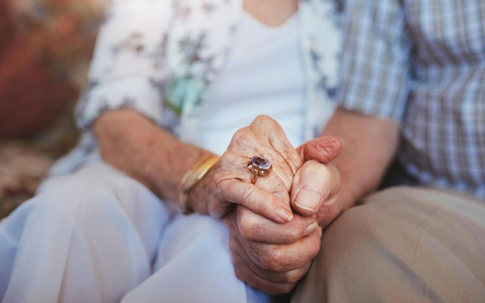 Ein älteres Ehepaar beim Händchen halten. Symbolfoto