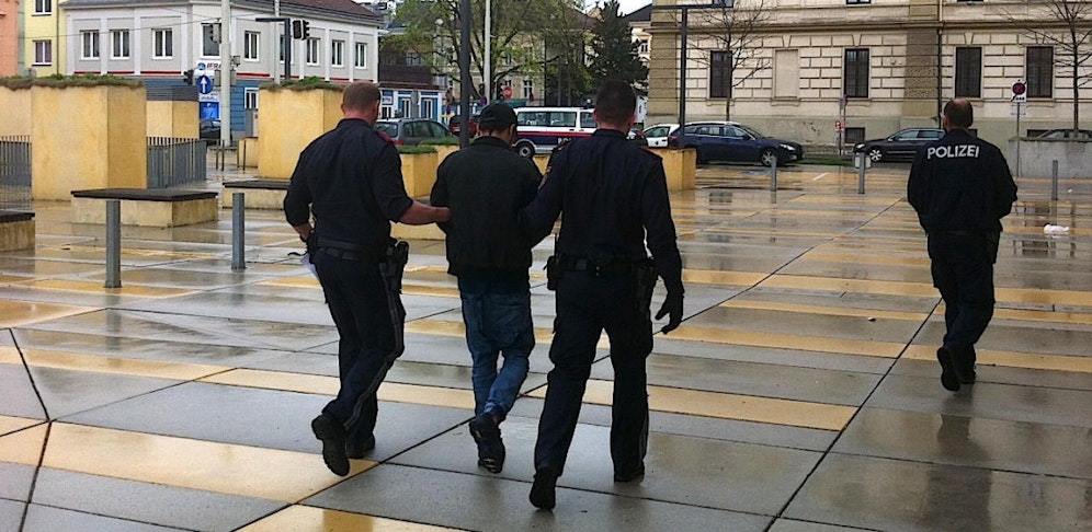 Der verurteilte Afghane wird von Polizisten zurück in die Schubhaft geführt.