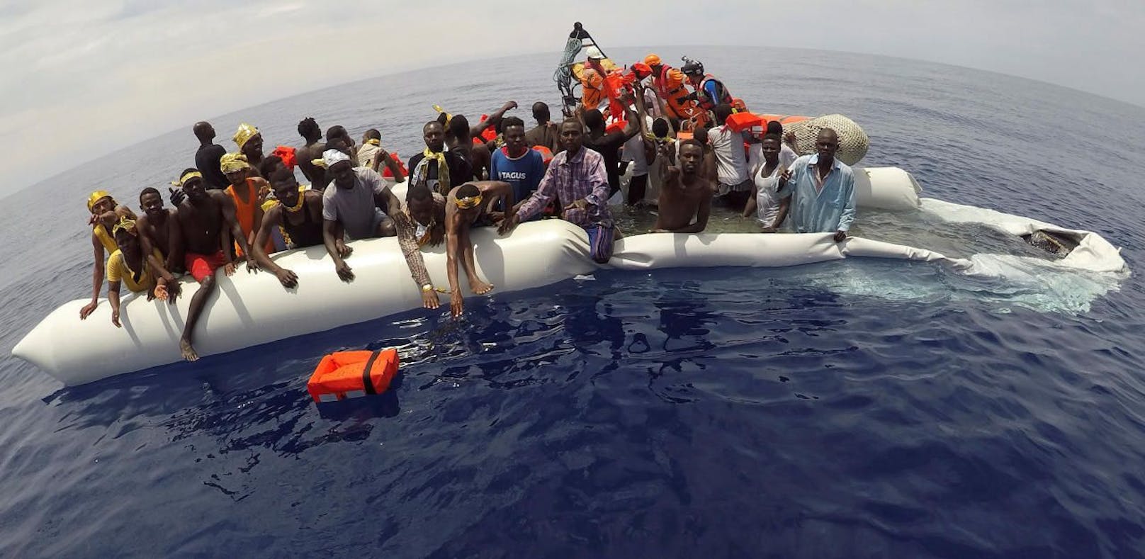 Flüchtlinge mit Rettern im Mittelmeer. Credit: Reuters 