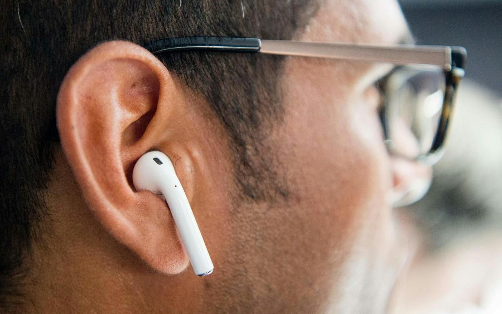 Apple Airpod im Ohr eines Mannes. Symbolfoto.