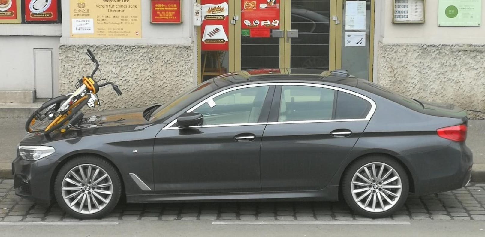Suboptimal geparkt: Ein oBike auf der Motorhaube eines BMWs