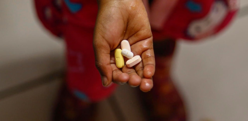 Ein südafrikanisches Kind in einem Heim für HIV-positive Kinder und Jugendliche in Kapstadt zeigt seine tägliche Medikamente.