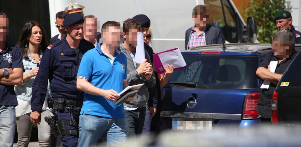Der mutmaßliche Messerstecher (in grauer Trainingsjacke) in Handschellen beim Lokalaugenschein.
