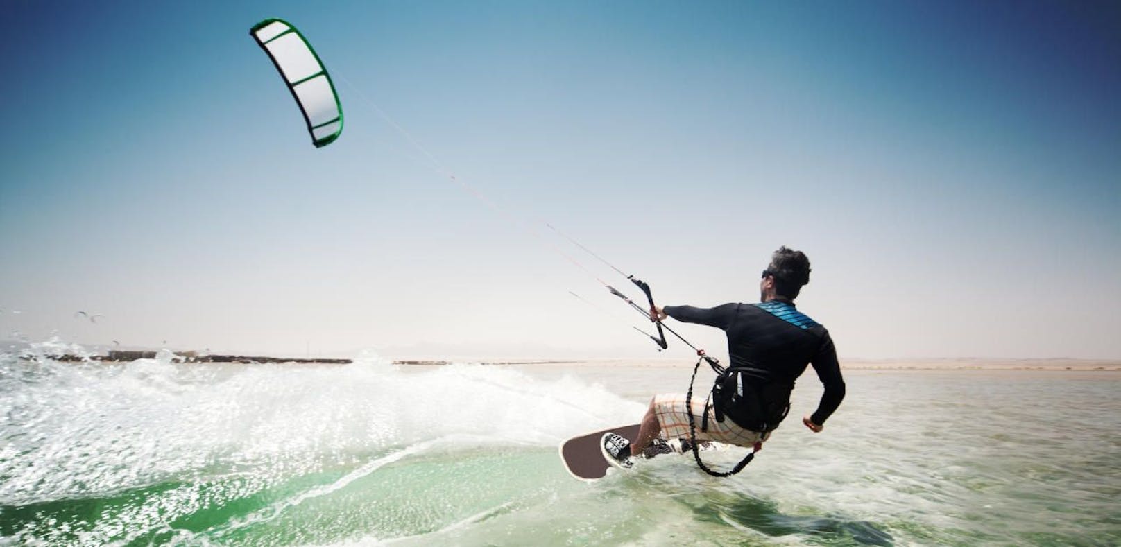 Ein Kite-Surfer pflügt durch das Wasser. Symbolfoto.