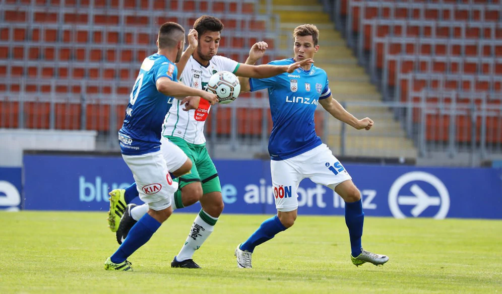 Florian Maier und Ante Anic (beide Blau Weiß) nehmen Innsbrucks Okan Yilmaz in die Zange