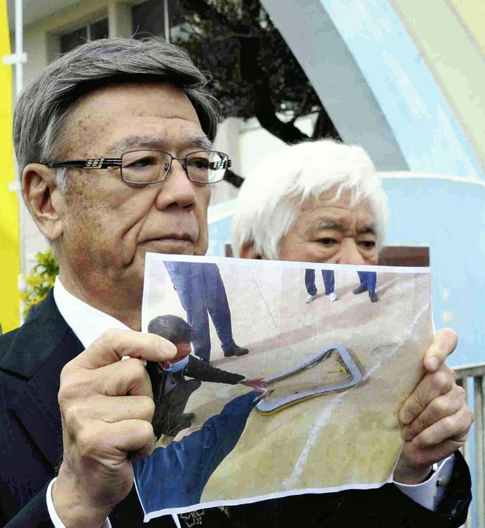 Empört: Regional-Gouverneur Takeshi Onaga zeigt ein Bild des Fensters, dass die Grundschule in Okinawa traf. 