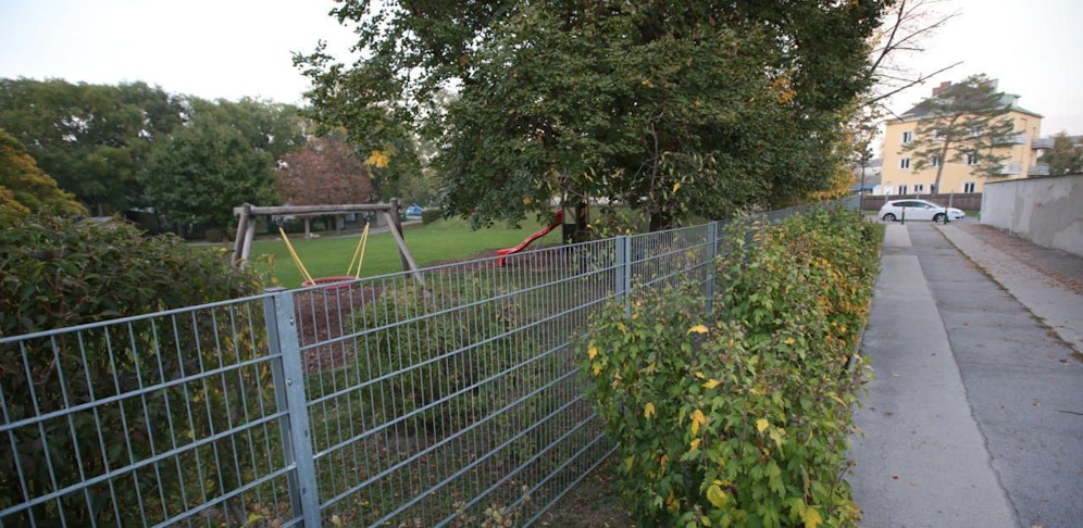 Am Zaun des Kindergartens wird an manchen Stellen ein Sichtschutz angebracht.