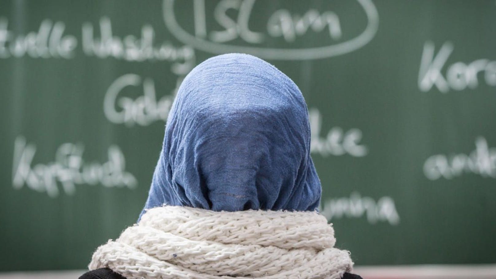 Eine junge Frau mit Kopftuch sitzt am 05.02.2015 in einer Schule in Frankfurt am Main (Hessen) bei einer Unterrichtsstunde zum Thema Islam.