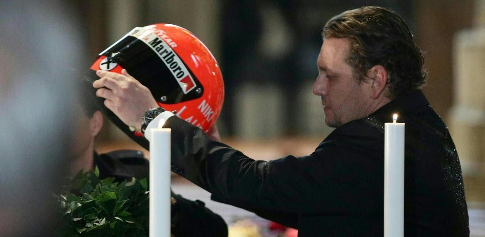 Sohn Lukas platziert den roten Rennhelm auf dem Sarg von Niki Lauda.