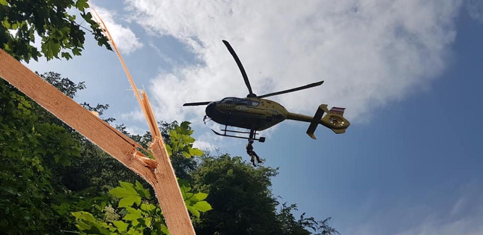 Foto von der Heli-Rettung und Symbolbild eines gebrochenen Holz.