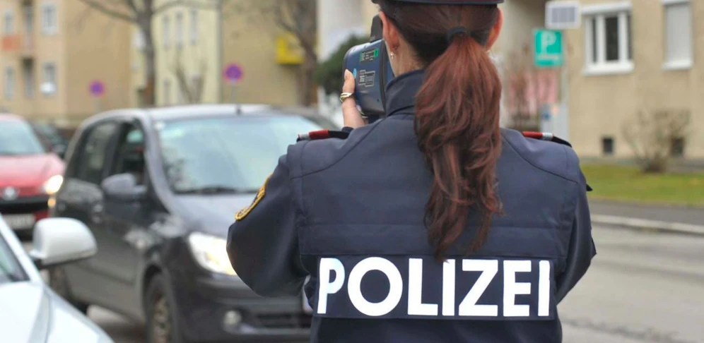 Symbolbild einer Polizistin mit Radarpistole.