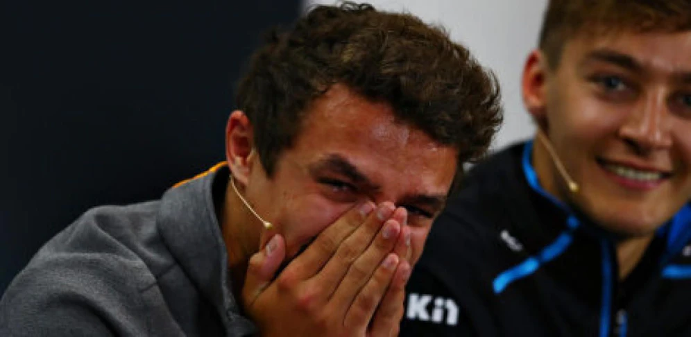 Lando Norris kämpft mit einem Lachkrampf, nachdem ihm Daniel Ricciardo eine anzügliche Frage gestellt hat.