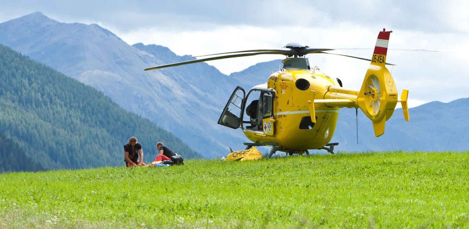 Flugrettung, die Mannschaft des OeAMTC-Hubschraubers Christophorus 7 versorgen Ausrüstung und Gerät auf einer Wiese nach einer Taubergung. 