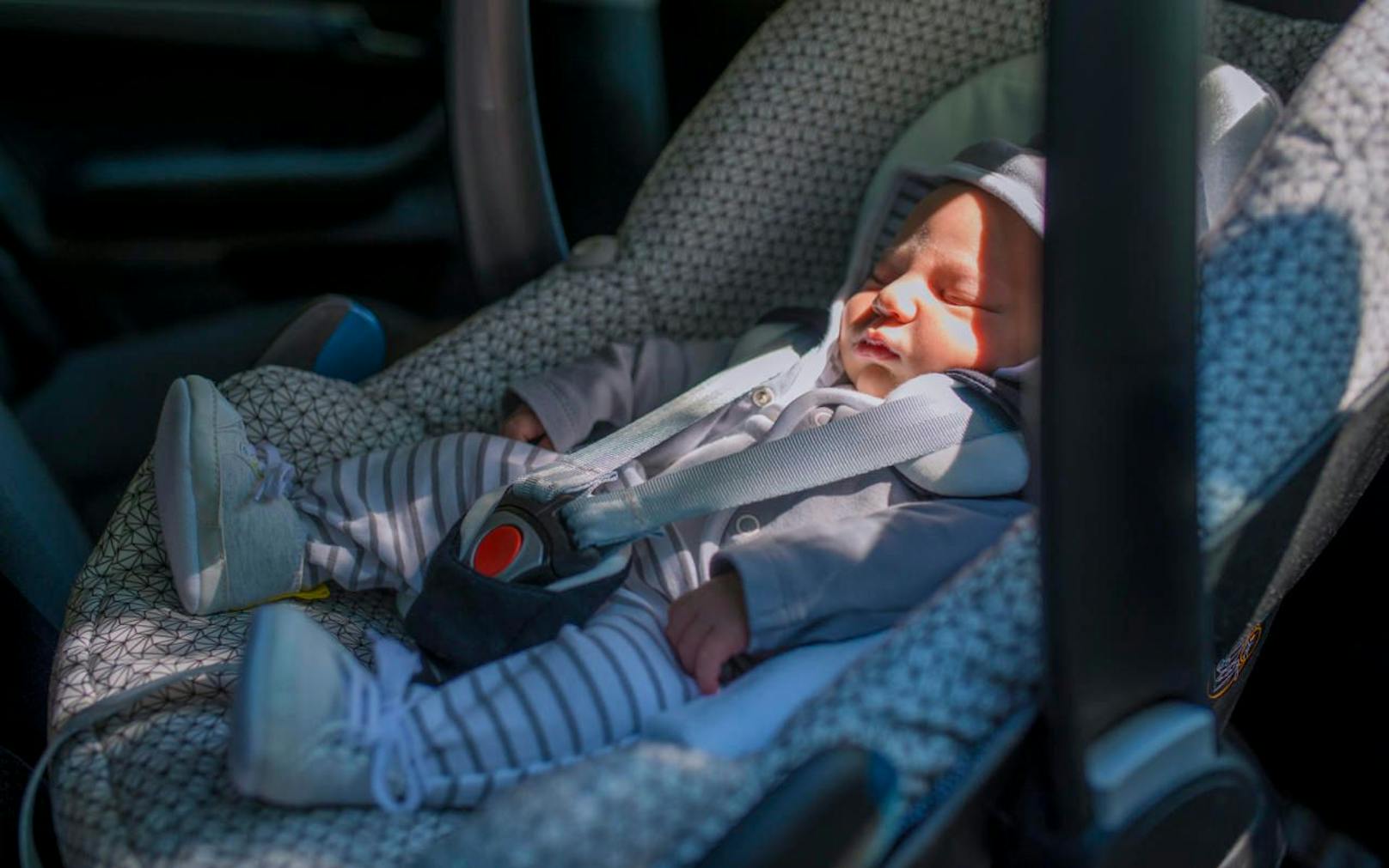 Ein Neugeborenes schläft in einem Kindersitz im Auto. Symbolfoto.