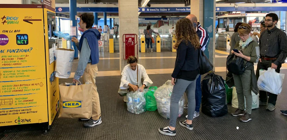 Menschen stehen Schlange, um Plastikflaschen gegen Tickets einzutauschen.