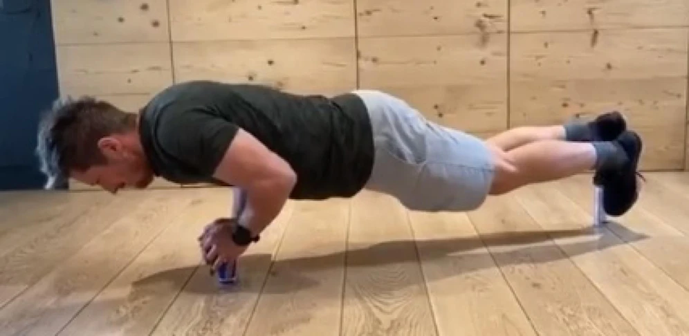 Marcel Hirscher balanciert auf Red-Bull-Dosen und macht Liegestütze.