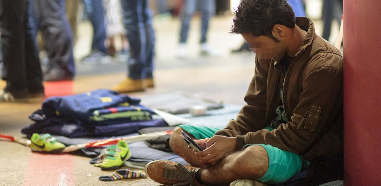 Ein Flüchtling mit seinem Handy am Hauptbahnhof Salzburg im Jahr 2015.