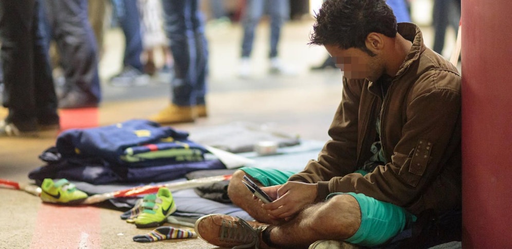 Ein Flüchtling mit seinem Handy am Hauptbahnhof Salzburg im Jahr 2015.