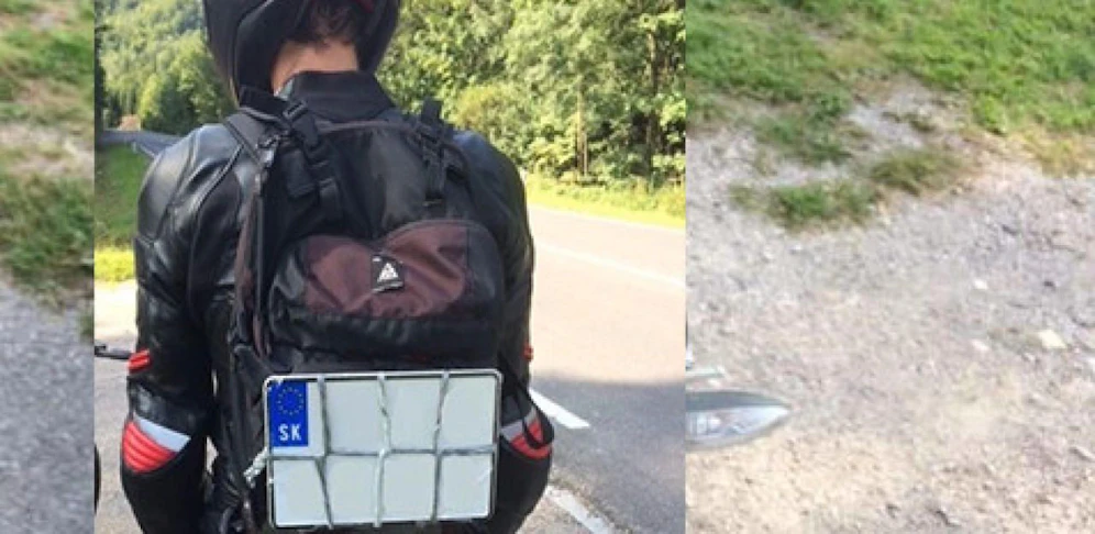 Biker mit Taferl am Rücken.