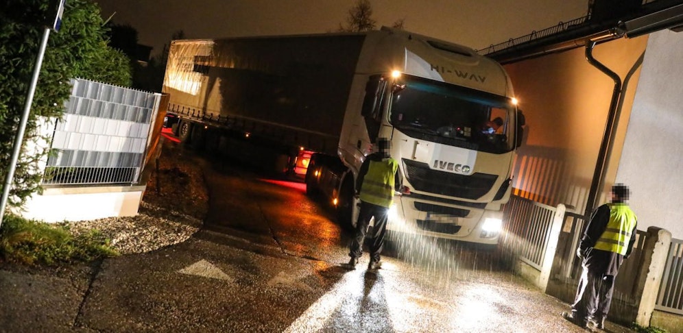 Das Schwerfahrzeug steckte zwischen Gartenhecke, Zaun und einer Dachrinne fest