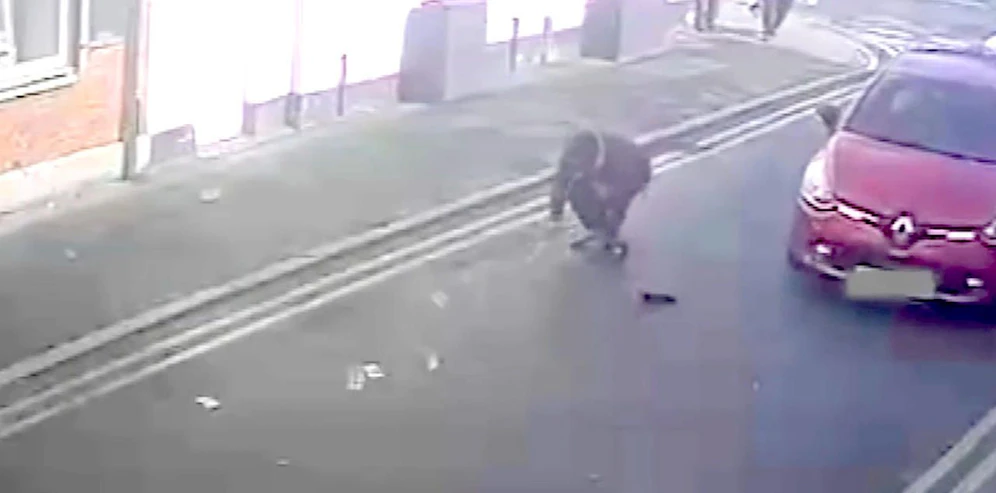 Kann man helfen? Der Räuber sammelt seine Beute wieder ein und wird dabei beinahe von einem Auto überfahren.