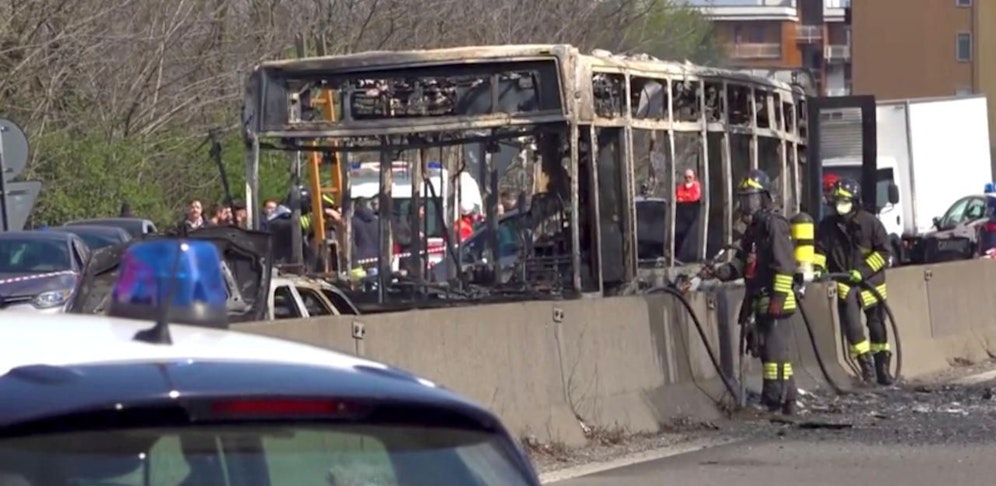 Der abgebrannte Schulbus auf einer Straße in Mailand. Der Fahrer ließ die Kinder aussteigen, bevor der das Fahrzeug wohl aus Protest gegen die Flüchtlingspolitik der italienischen Regierung in Brand setzte. 