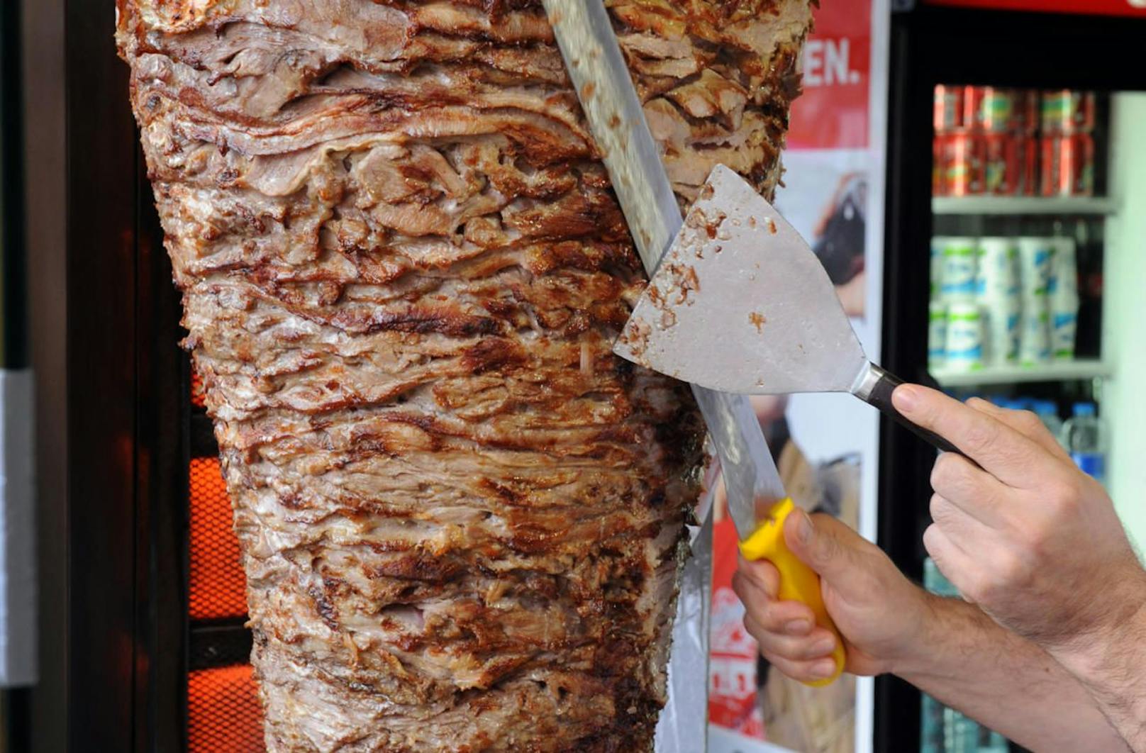 Ein Verkäufer schneidet Fleisch von einem Döner-Spieß. Symbolfoto