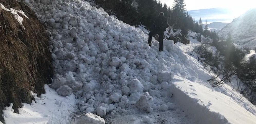 Der Traktor wurde von der Lawine von der Straße gerissen.