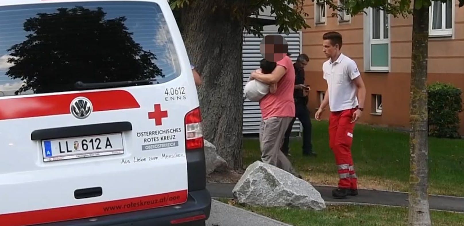 Rettungseinsatz in Enns (Bez. Linz-Land): Ein einjähriger Bub hatte sich dort mit Tee schwer verbrüht. Die Mutter bringt ihn zum Rettungswagen.