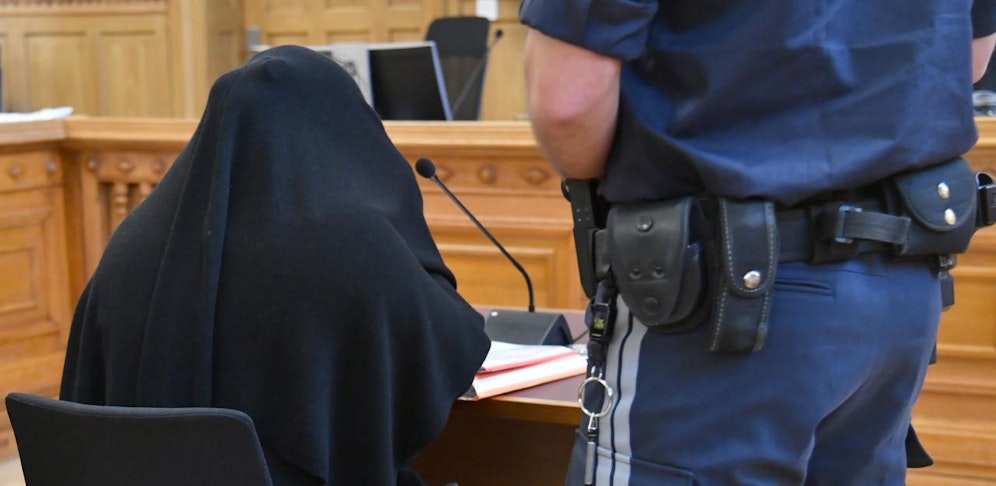 Die vermummte Angeklagte beim Prozess.