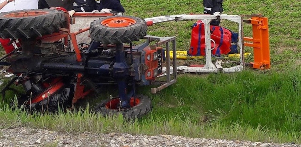 Gegen Windschutzscheibe geknallt: Der Landwirt kippte mit seinem Traktor um.