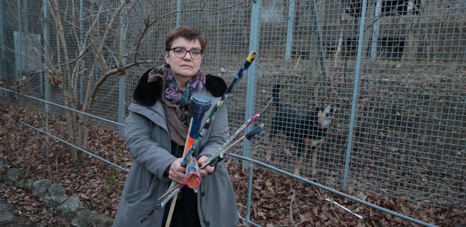 Madeleine Petrovic, Präsidentin des Tierschutzvereins, mit Raketen-Resten  und einem der panischen Hunde im Hintergrund.
