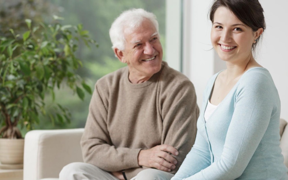 Smiling grandpa and caring granddaughter at home