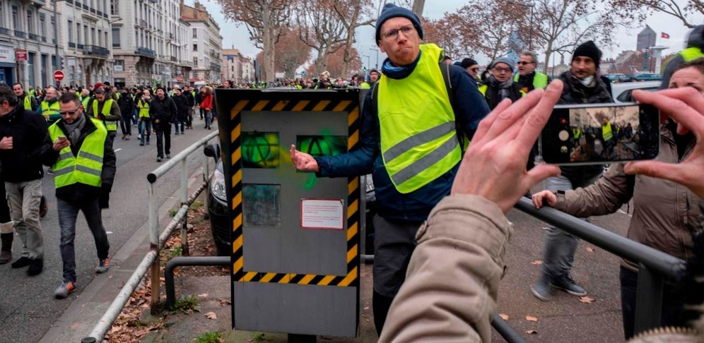 Gelbwesten posieren mit einer beschädigten Radarkamera.
