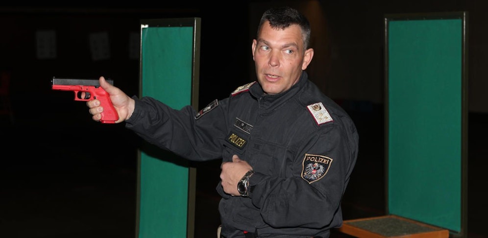 Ein Polizeitrainer demonstriert den Umgang mit der Schusswaffe.