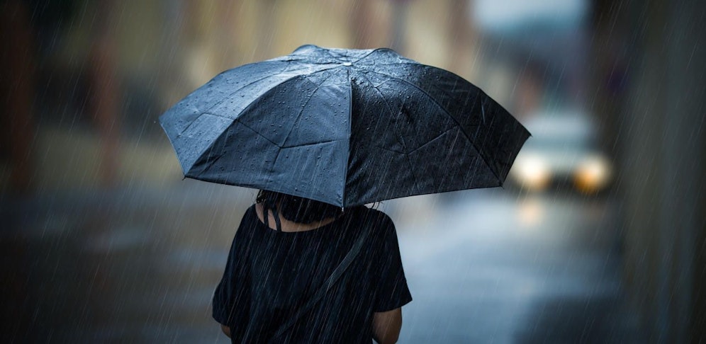 Girl walking with umbrella on rainy day