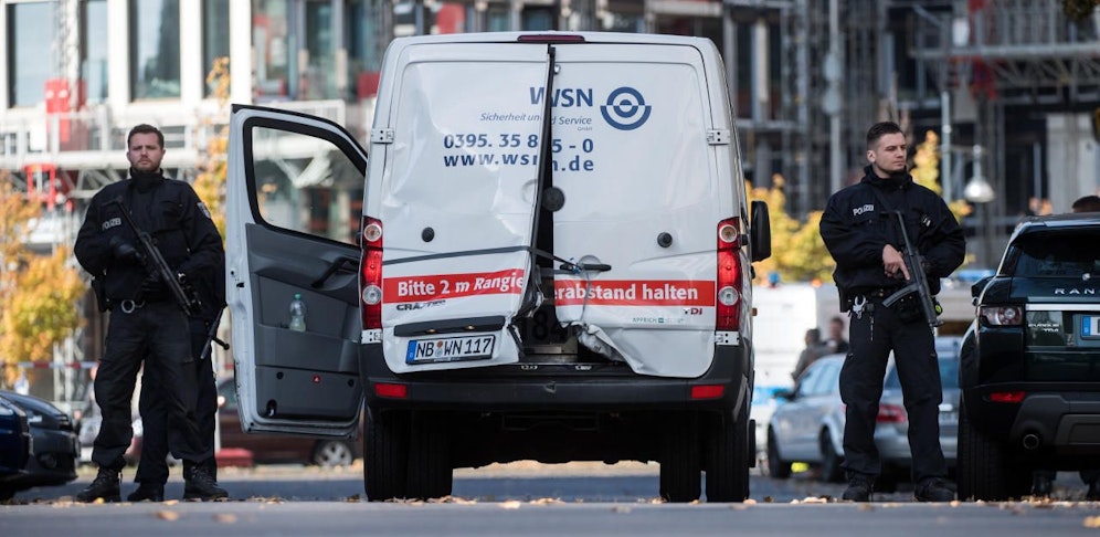 Polizisten sichern den aufgebrochenen Geldtransporter.