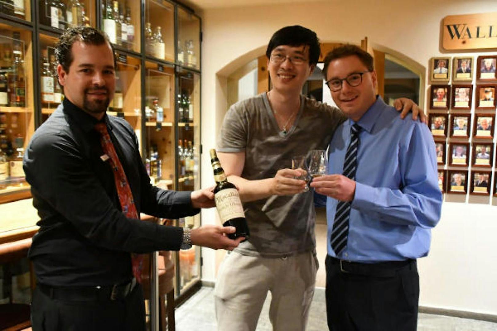 Prost: Der Gast aus China (Bildmitte) und Hotelier Sandro Bernasconi (rechts). Der Macallan-Sammler aus Asien hat sich soeben in einem Schweizer Hotel ein Glas Whisky für 8.700 Euro gegönnt.