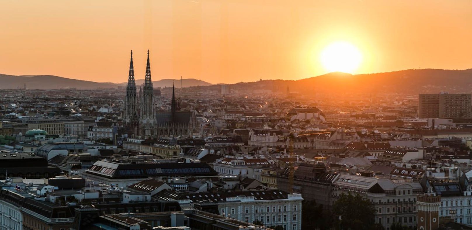 Blick über Wien mit Votivkirche und Sonnenuntergang