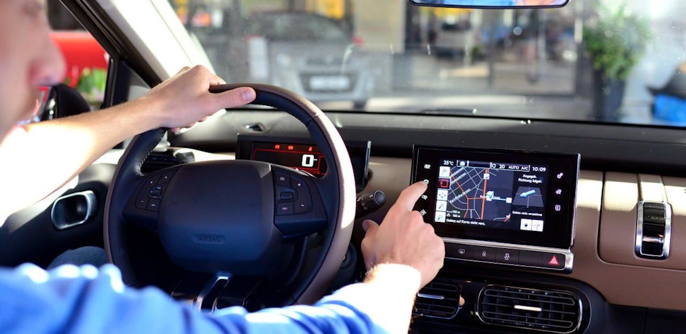Der Fahrer bediente während seiner Fahrt das Navigationsgerät.